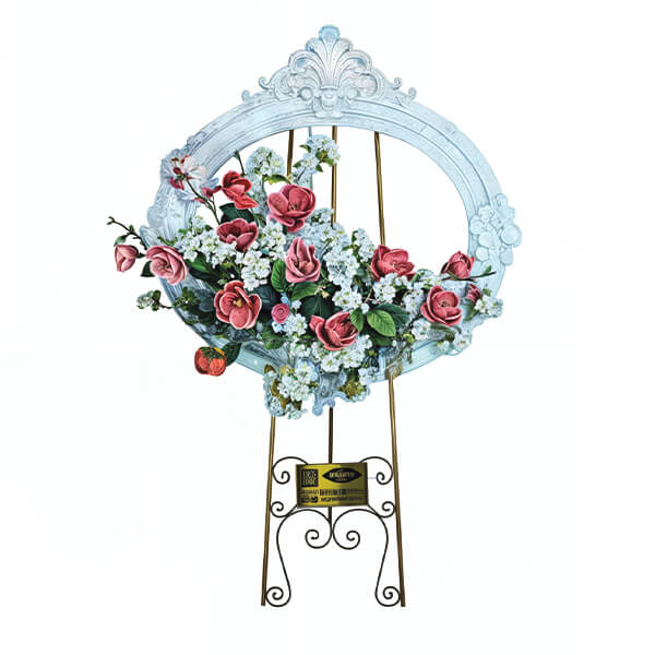 تابلوگل هانل ویژه مراسم شادی، با قاب بیضی سفید رنگ منبتکاری شده و گلهای صورتی و سفید که بر روی یک سهپایه فلزی طلایی قرار گرفته است - محصول خیریه مهربانان