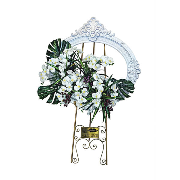 تابلوگل تبریک مدل درناز با گلهای ارکیده سفید و برگهای مونسترا، قرار گرفته بر روی یک قاب سفید تزئینی و پایه فرفورژه طلایی، از محصولات خیریه مهربانان